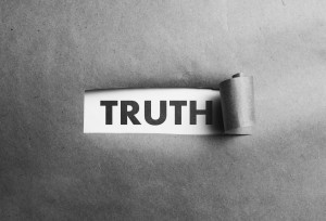 Torn paper with truth word behind it, black and white photo